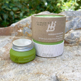 Humanist Beauty Herban Wisdom Eye Cream on a stone surface with greenery in the background