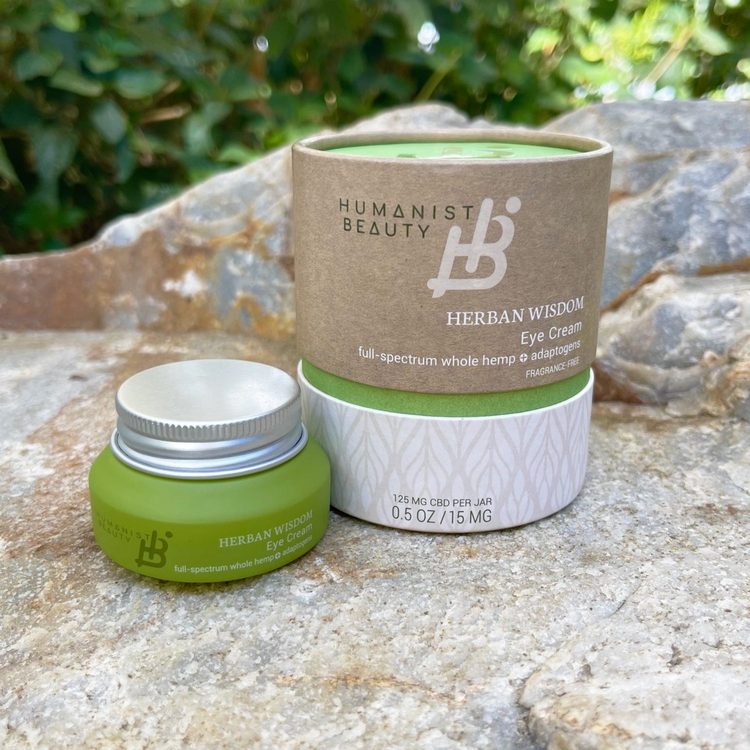 Humanist Beauty Herban Wisdom Eye Cream on a stone surface with greenery in the background